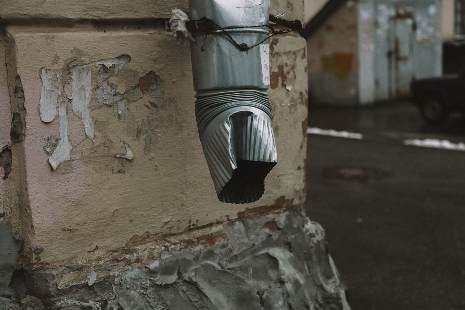Damaged sagging gutter section pulling away from a home's fascia board