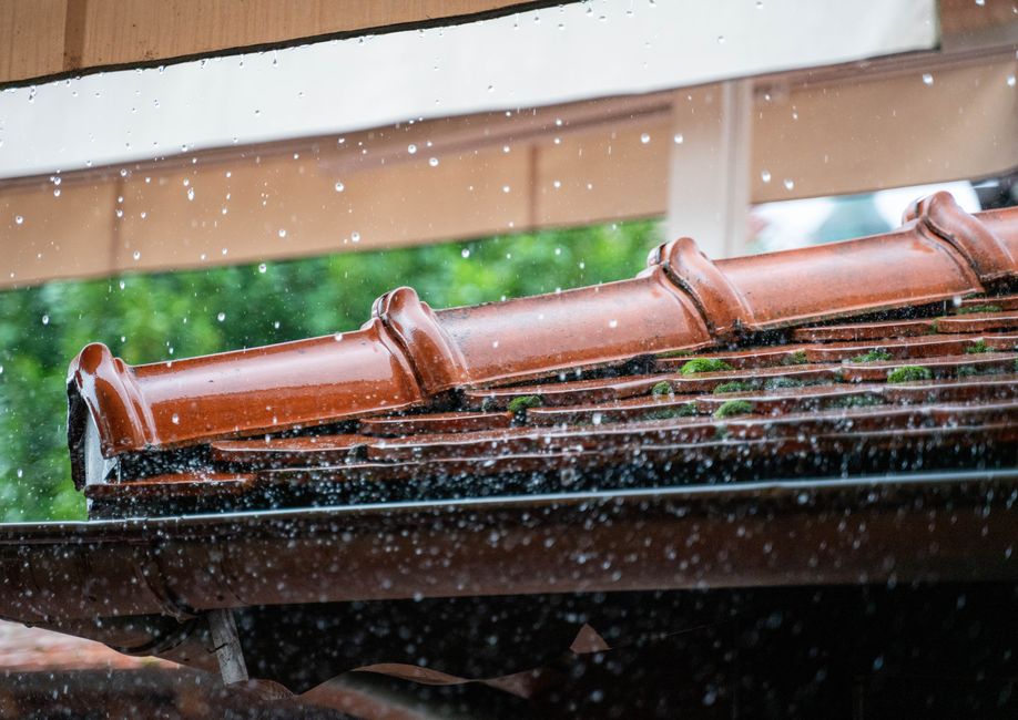 Overflowing gutter during rainfall along a home's roofline