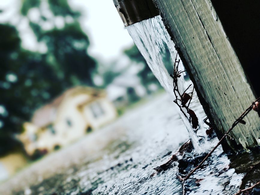 Close-up of a seamless gutter and downspout on a home exterior