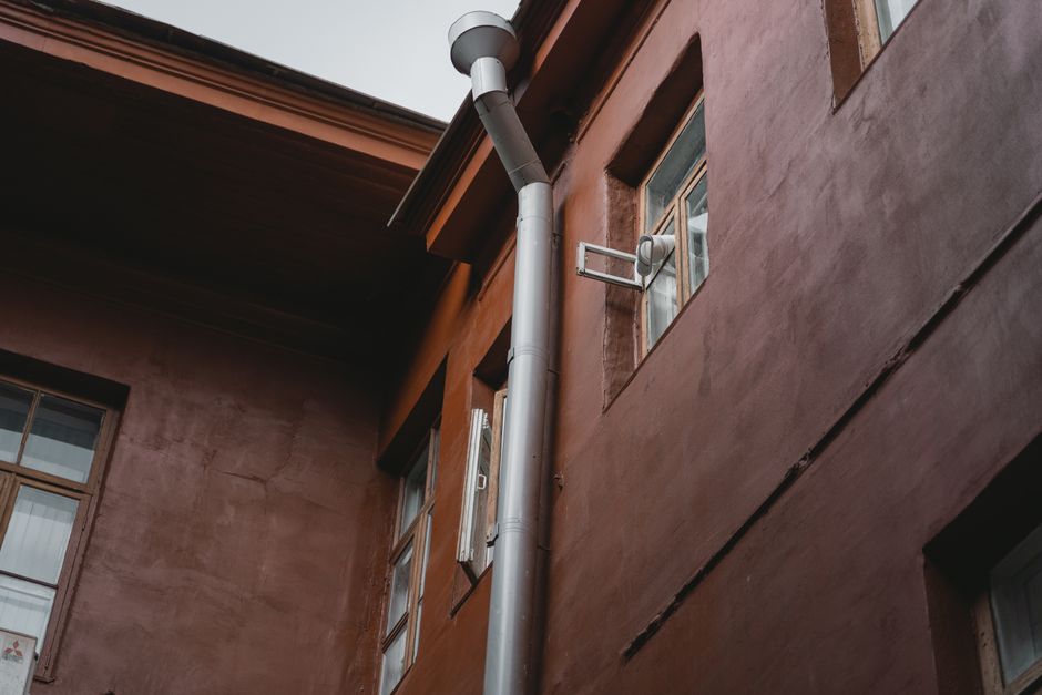 Downspout attached to a home's exterior directing water away from the foundation